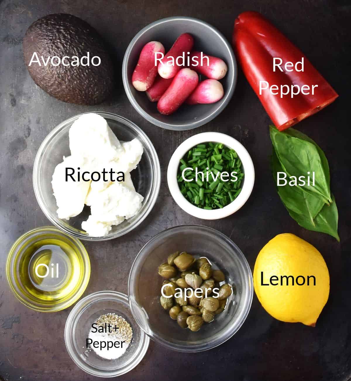 Top down view of ingredients for making avocado toast with ricotta in individual dishes.