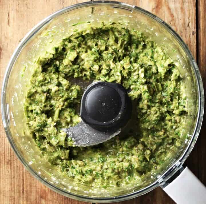 Top down view of creamy asparagus pesto sauce in food processor bowl.