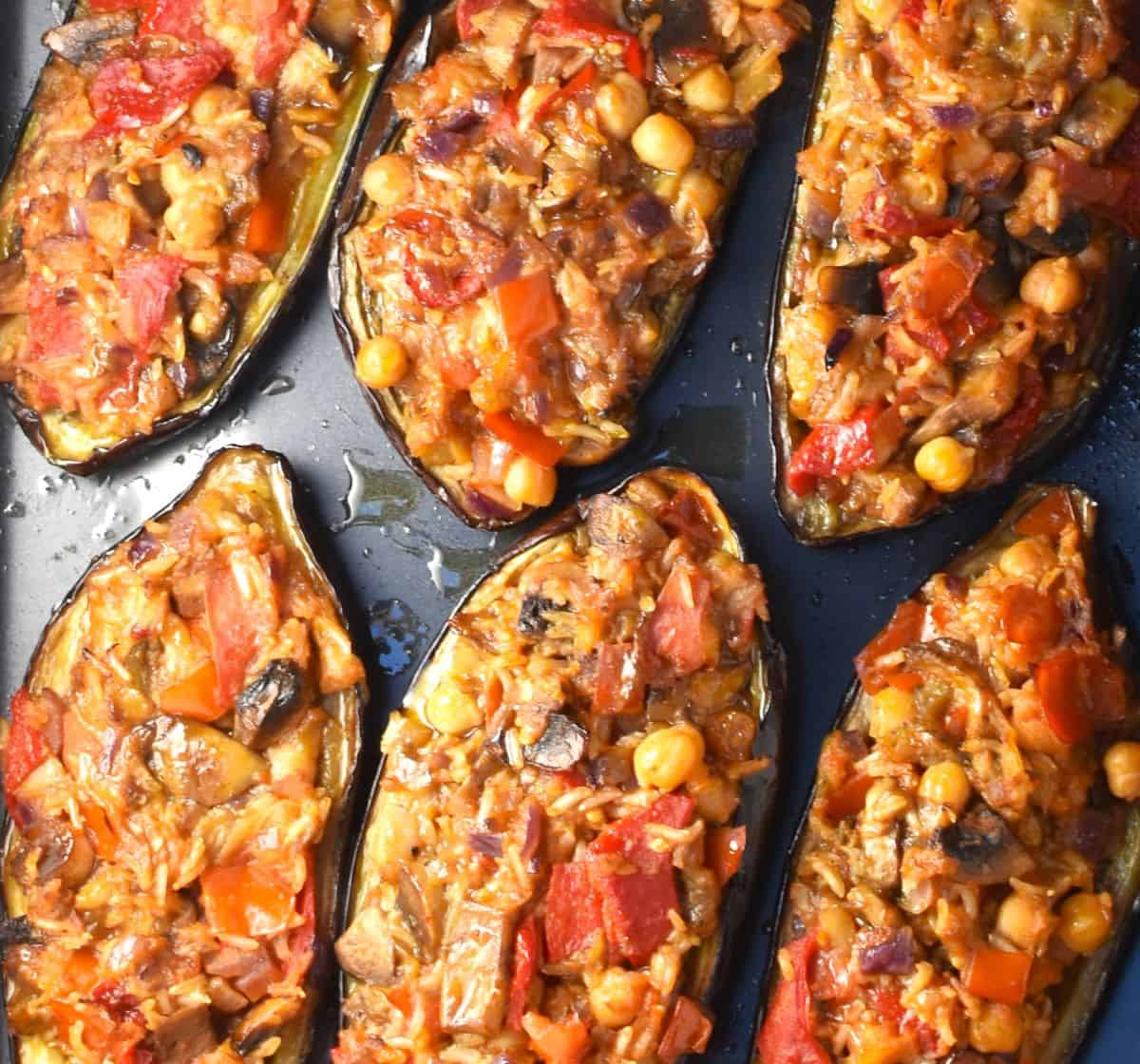 Top down view of 6 eggplant boats stuffed with rice and vegetarian mixture.