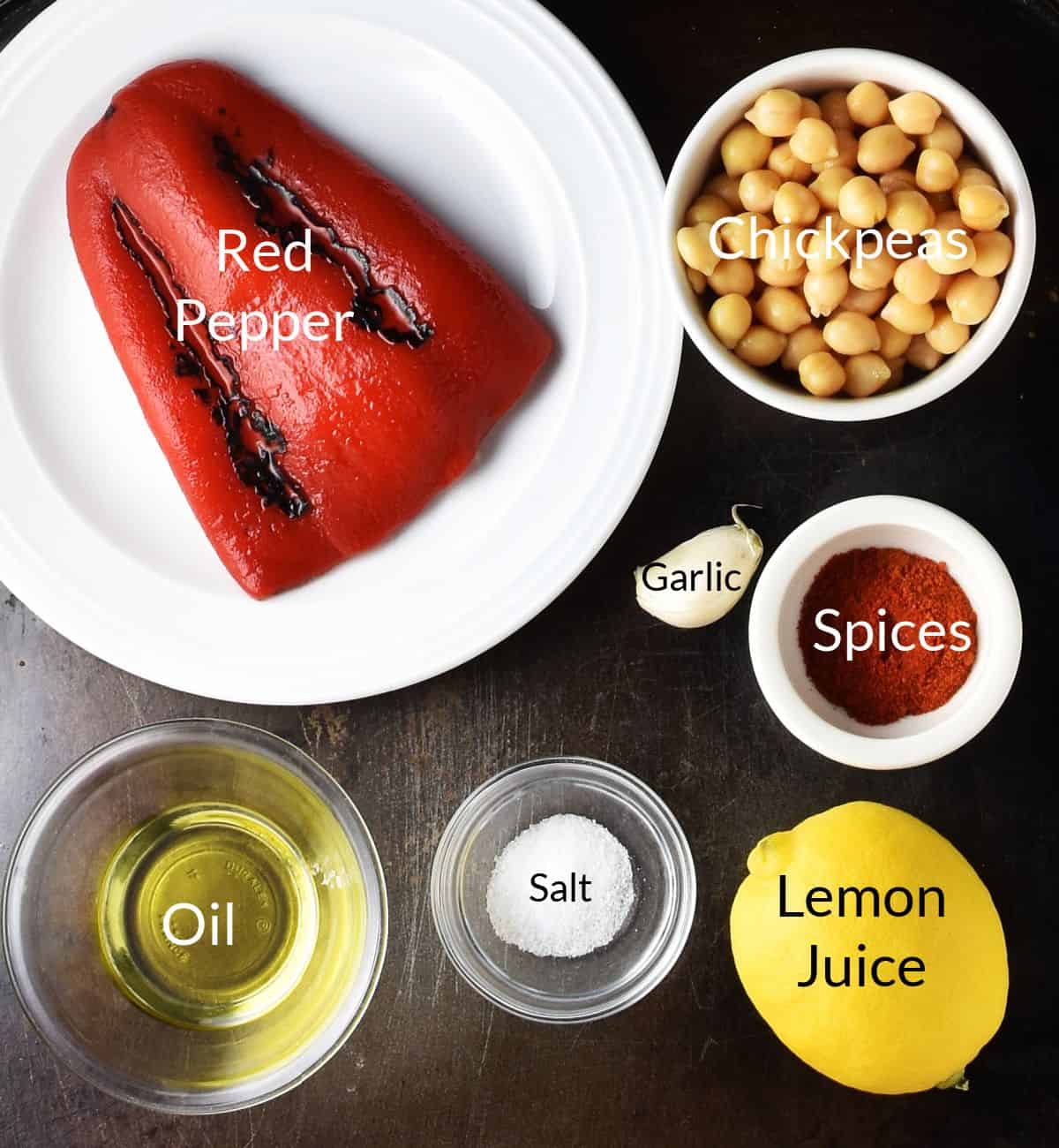 Top down view of ingredients for making roasted pepper hummus without tahini in individual dishes.
