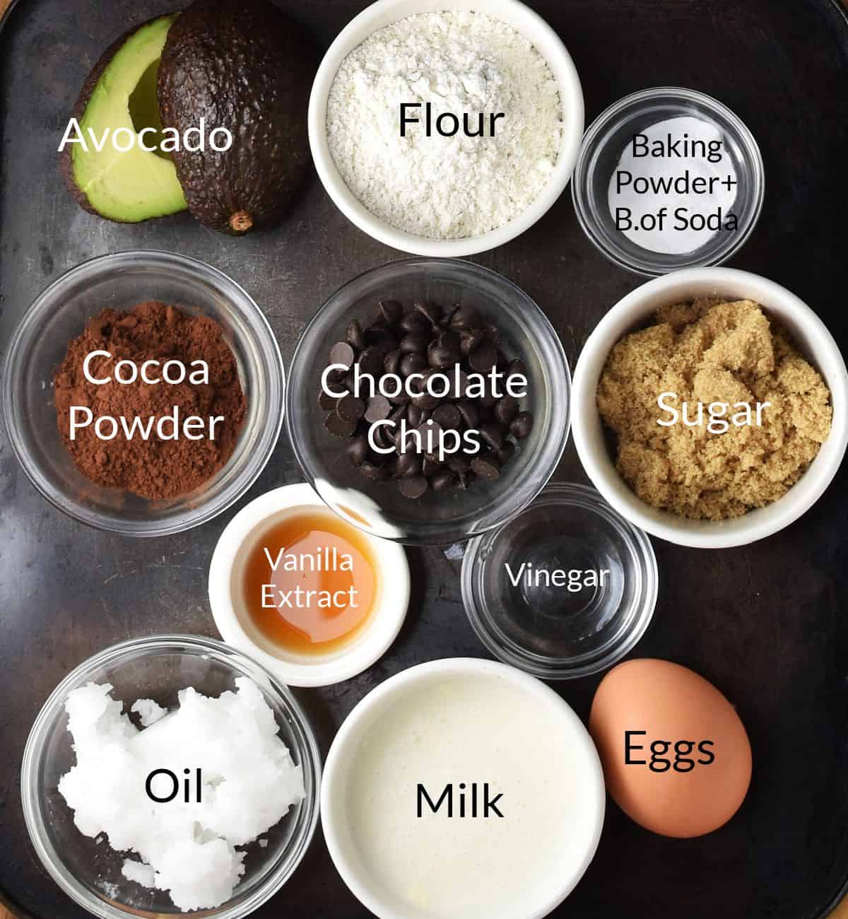 Top down view of avocado and chocolate muffins ingredients in individual dishes.