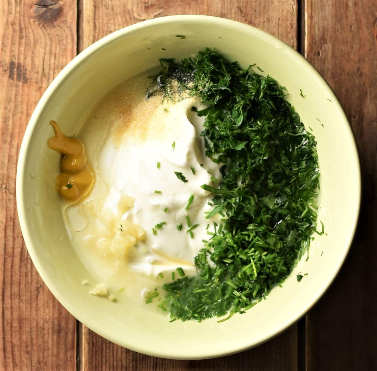 Healthy ranch dressing ingredients in yellow bowl.
