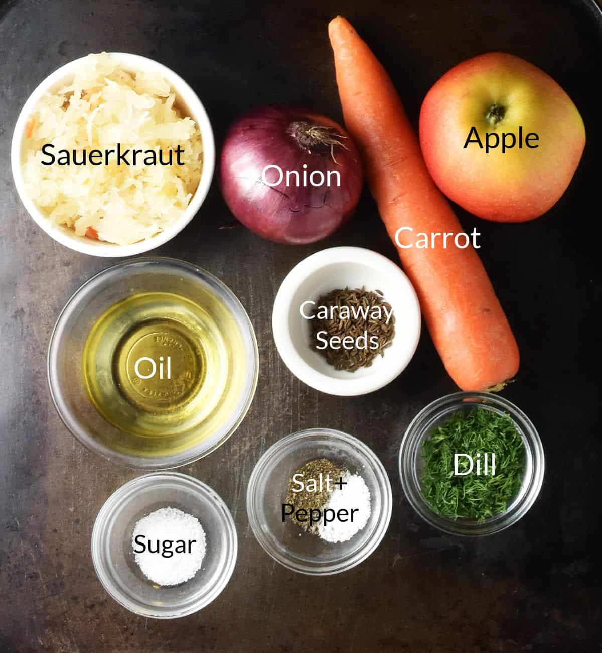 Ingredients for making sauerkraut salad in individual dishes on metal surface.
