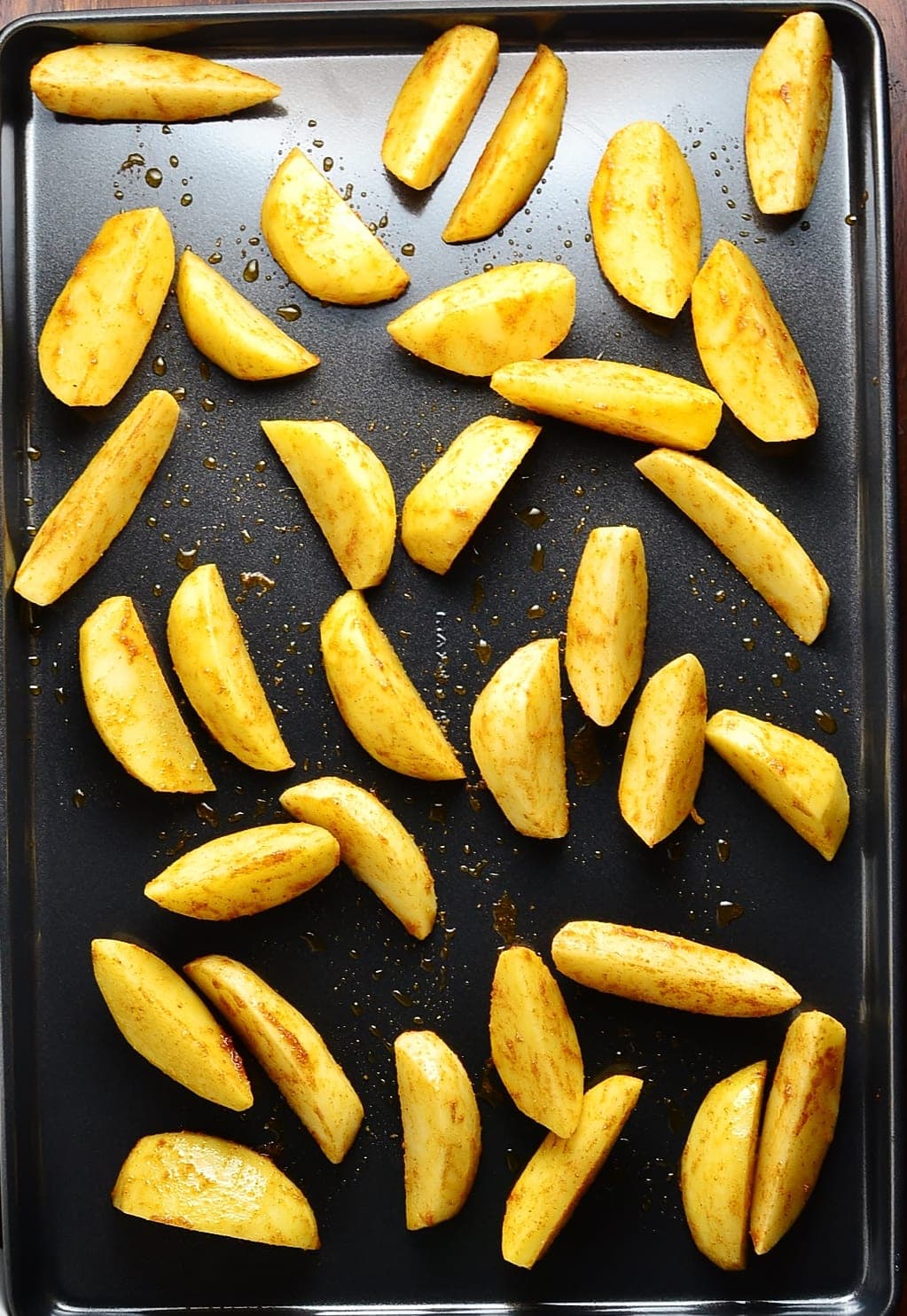 Top down view of potato wedges on top of tray.