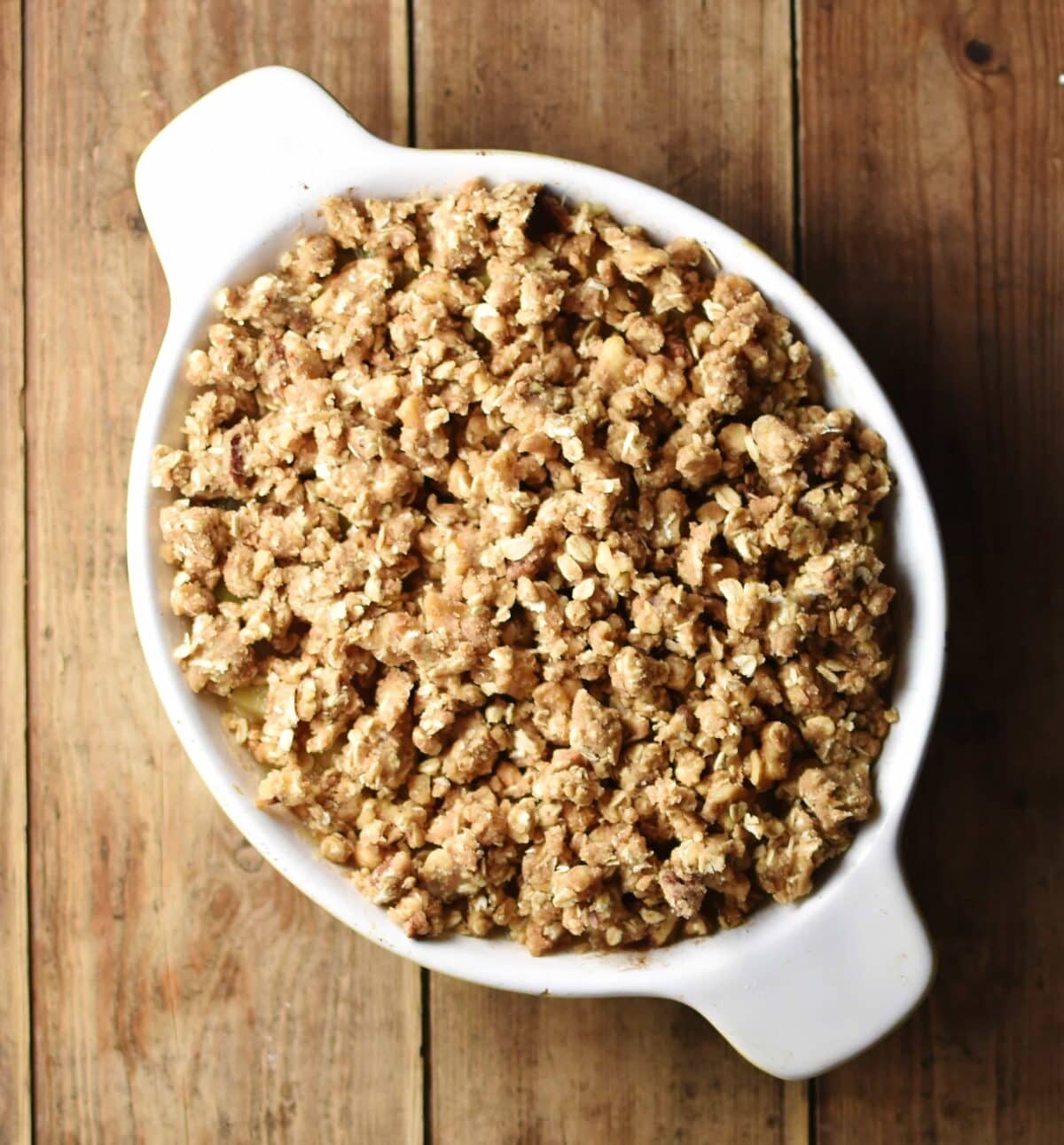 Raw crumble in white oval dish.
