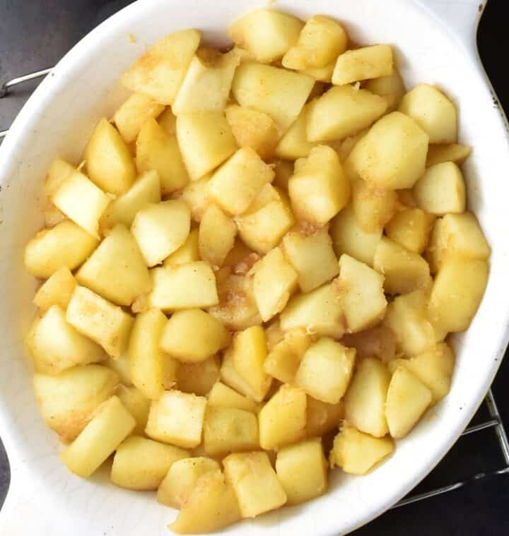 Cubed cooked apples in white dish for crumble.