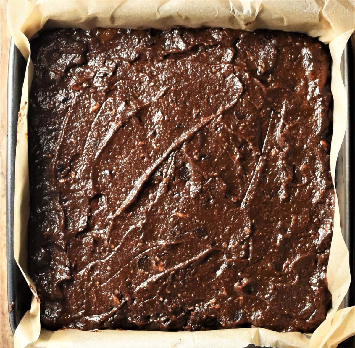 Unbaked brownies cake in square pan.