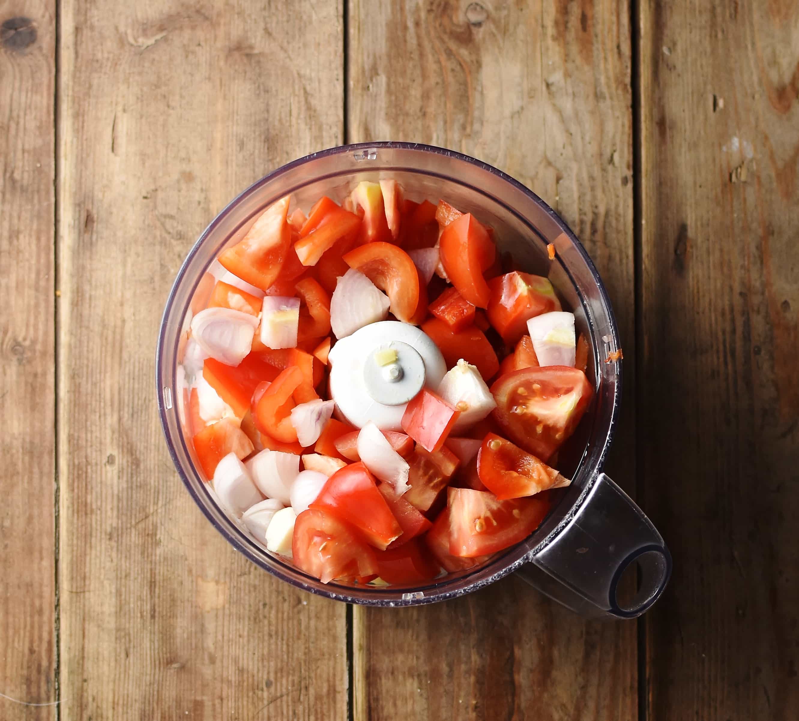 Chopped tomatoes with shallots in blender.