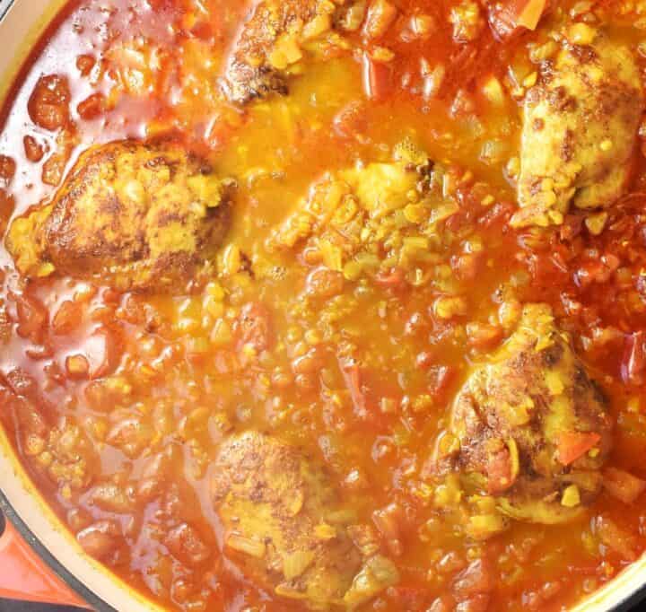 Curry sauce with lentils and chicken in large pan.