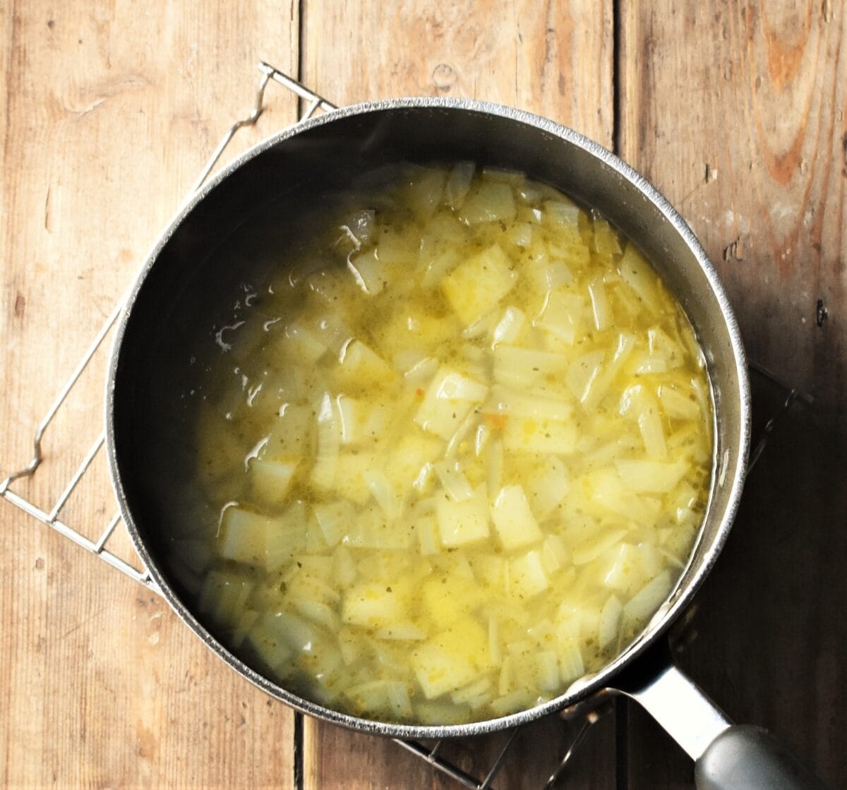 Cubed potatoes and chopped onion with stock in large pot.