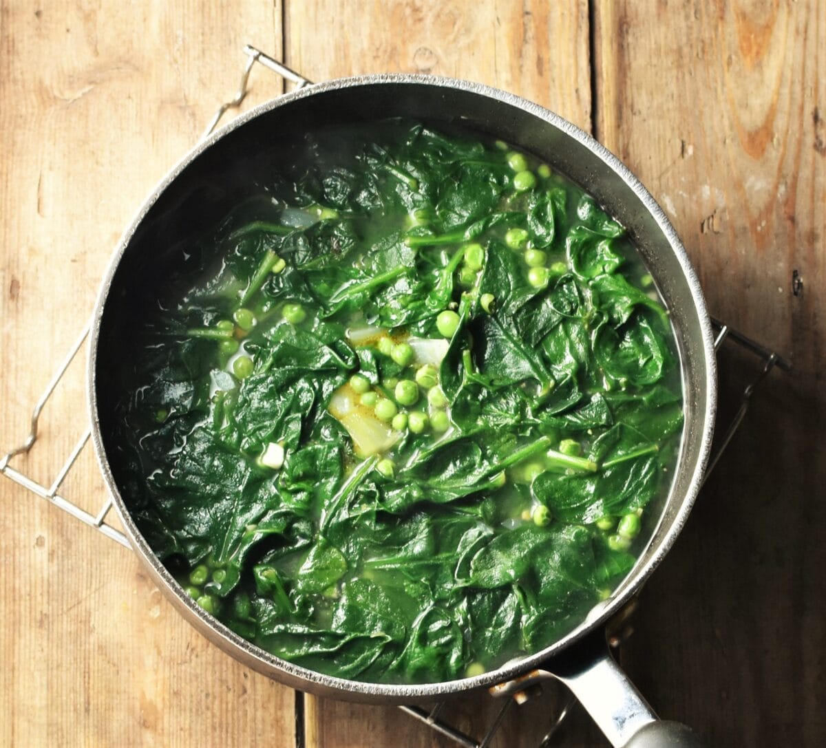 Spinach and peas in large pot with stock.