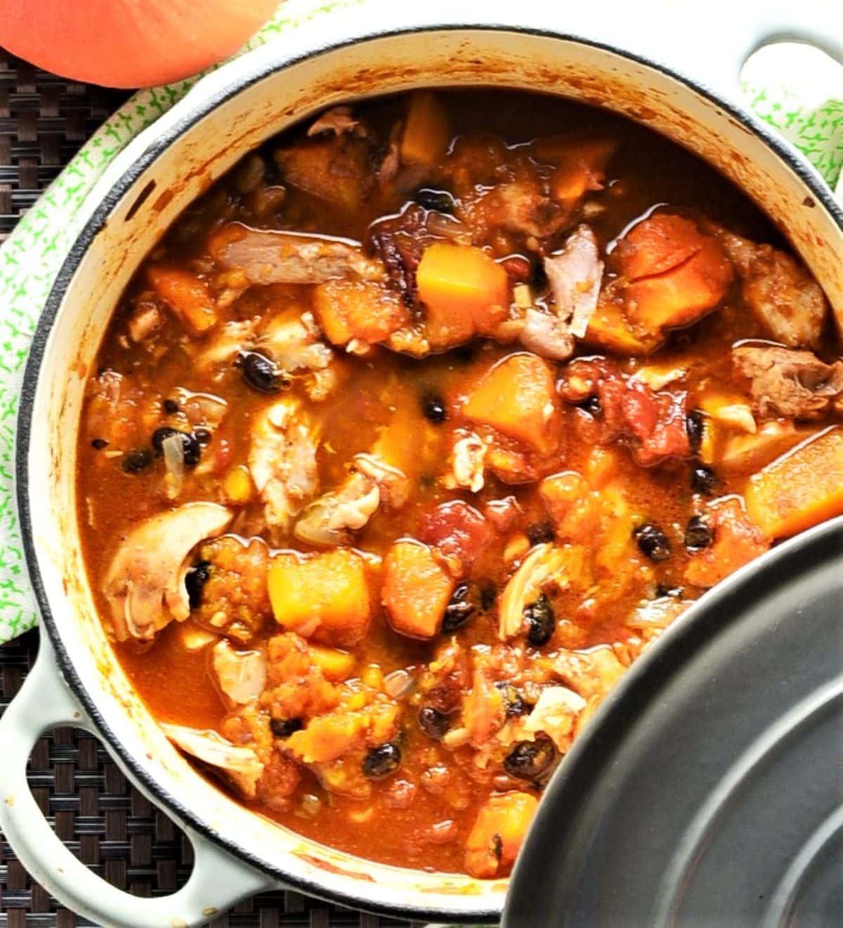 Top down view of chicken and squash casserole in large pot with lid.