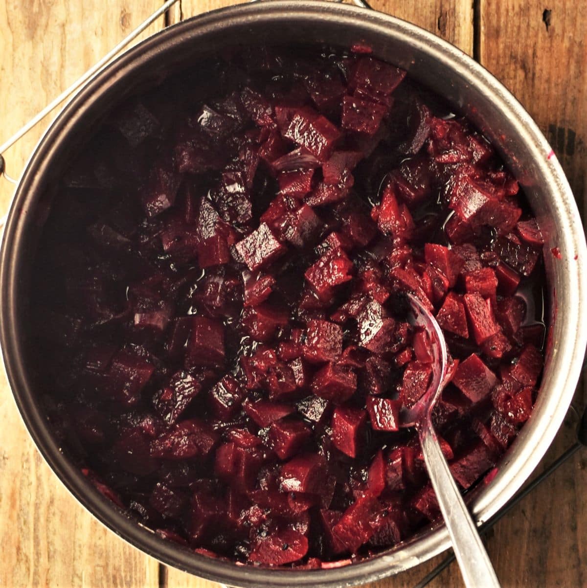 Beetroot chutney mixture in pot with spoon.
