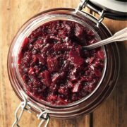 Top down view of beet chutney in open jar with spoon.