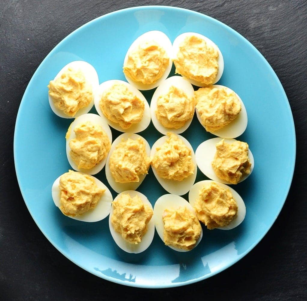 How To Make Smoked Salmon Deviled Eggs with Wasabi Top down view of deviled eggs on blue plate.