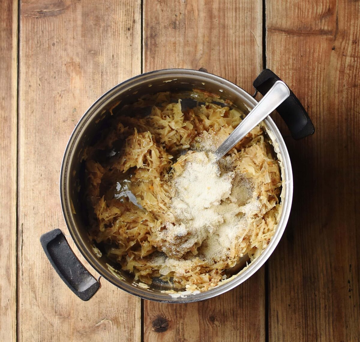 Sauerkraut mixture with breadcrumbs in pot with spoon.