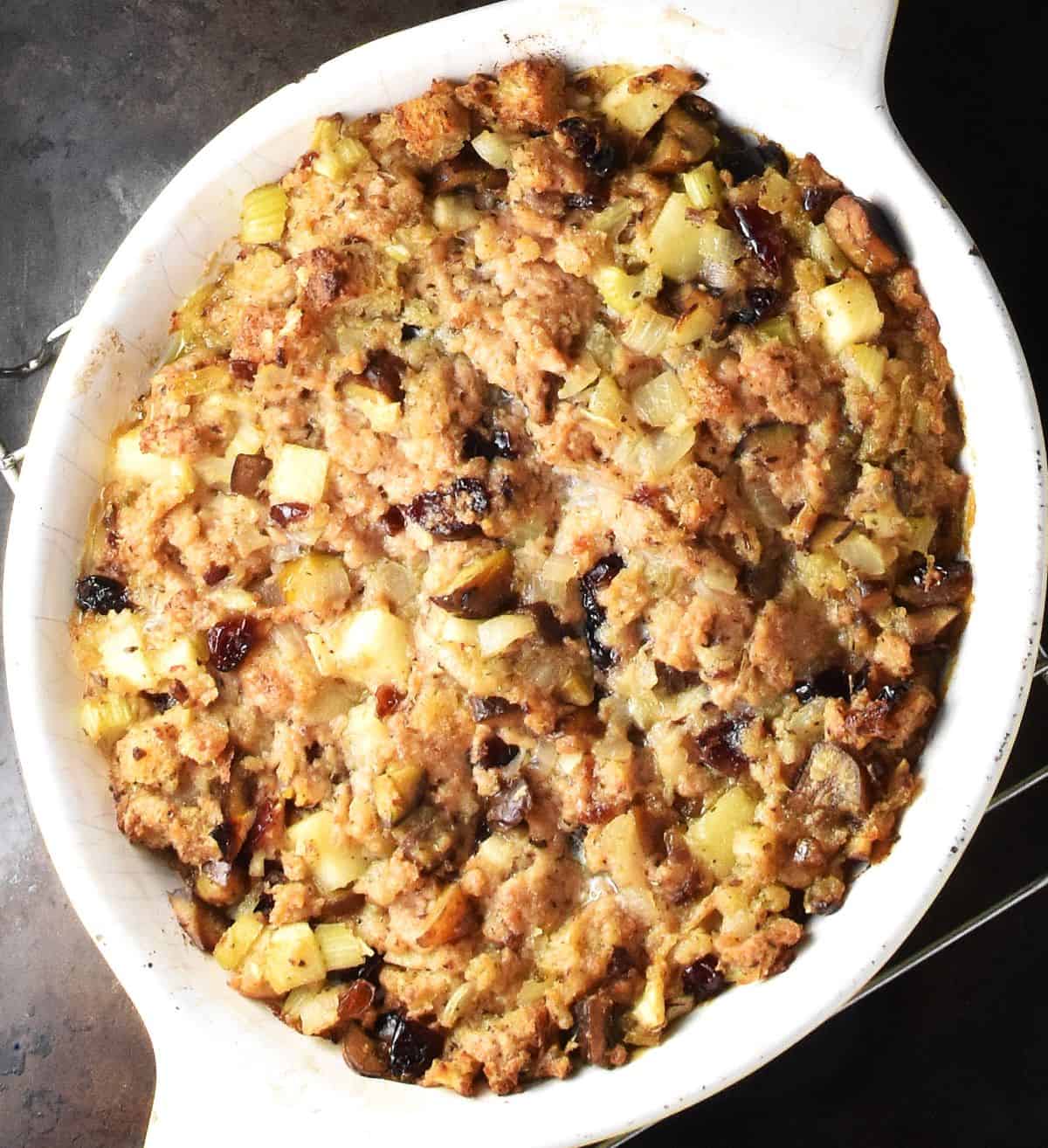 Top down view of baked vegan stuffing in white oval dish.