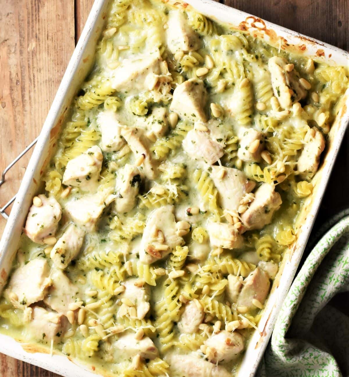 Creamy chicken fusilli pasta with pesto in rectangular dish.