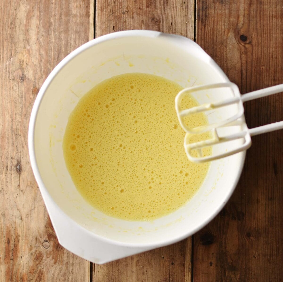 Beaten egg mixture inside white bowl.