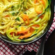 Partial top down view of chicken soup with veggie noodles.