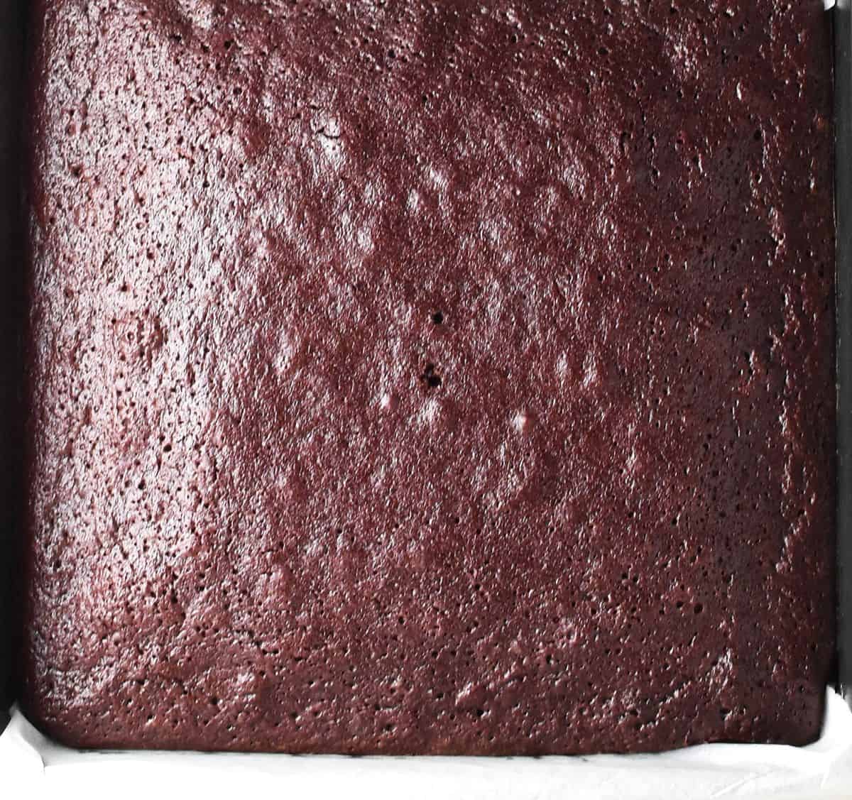 Top down view of baked brownie cake in pan.