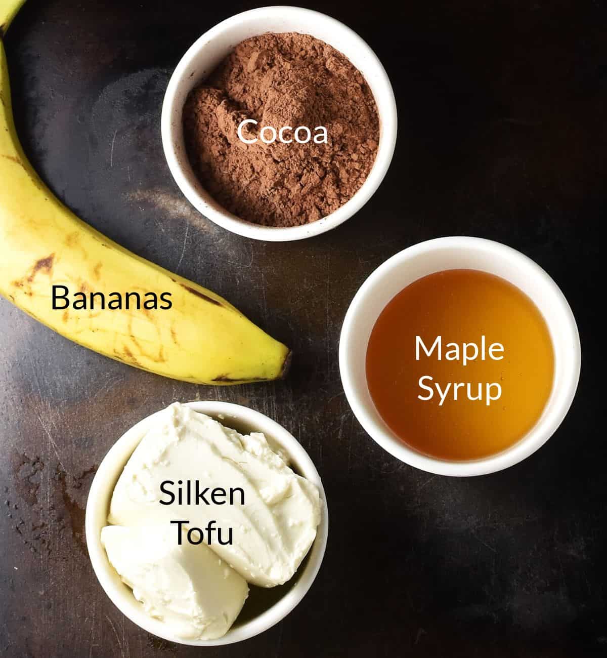 Top down view of chocolate banana pudding ingredients in individual dishes.