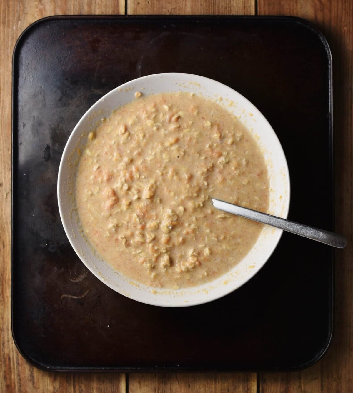 Top down view of overnight oats in white bowl with spoon.