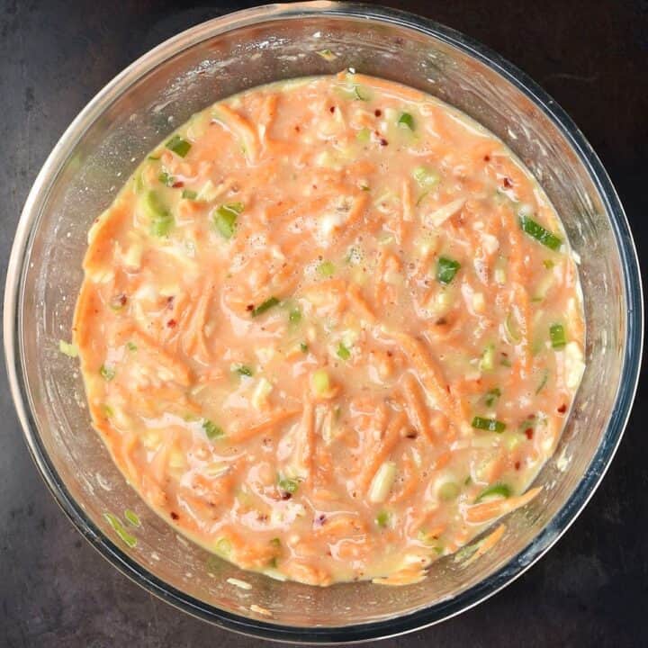 Egg muffin batter with shredded sweet potato in glass bowl.