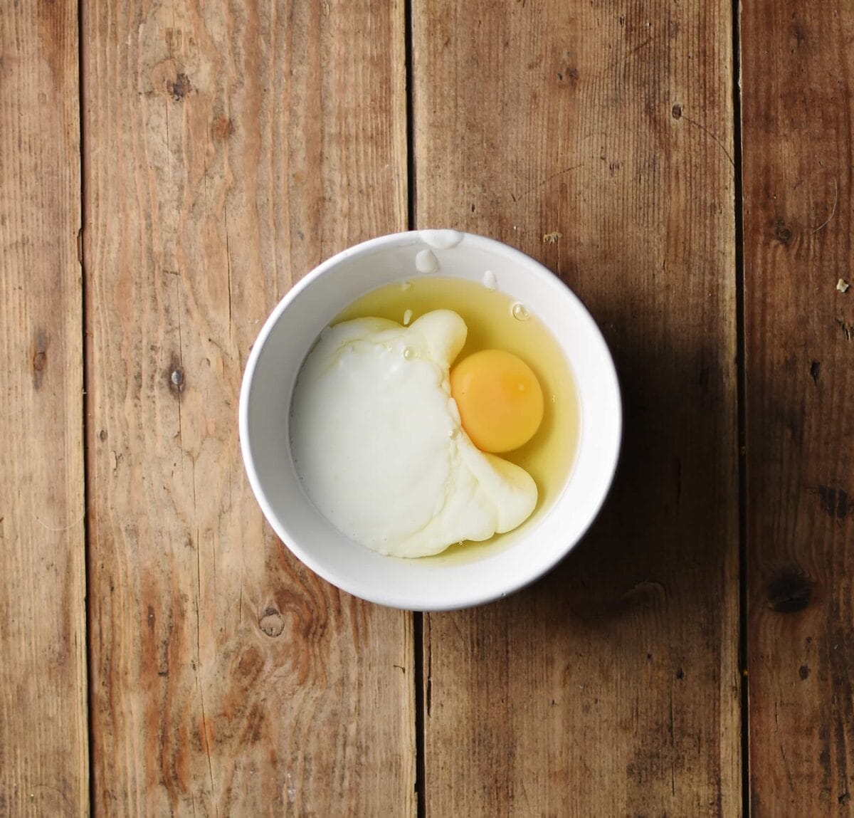 Egg and yogurt in small white bowl.
