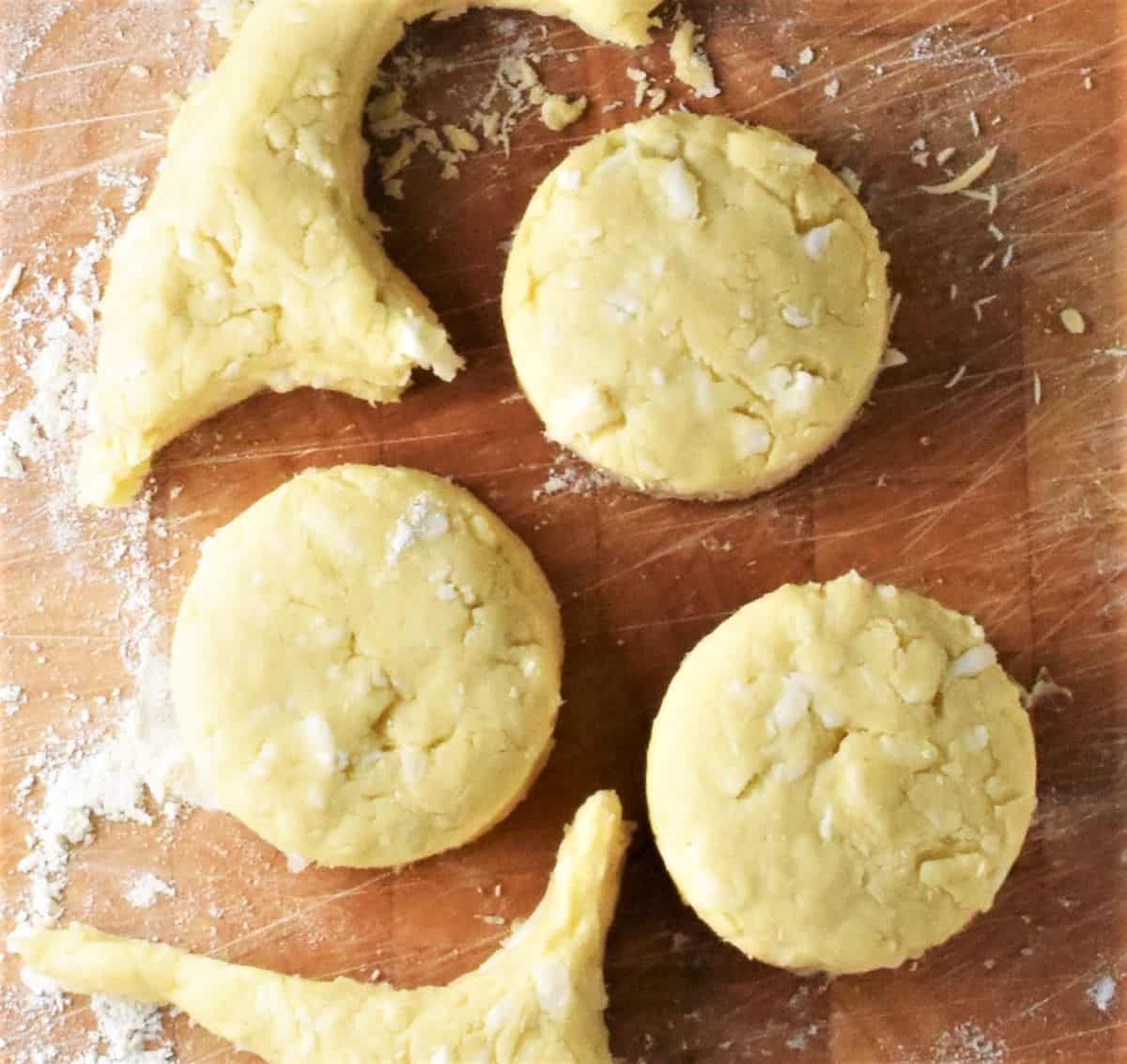 Cutting out cauliflower scones on top of wooden board.