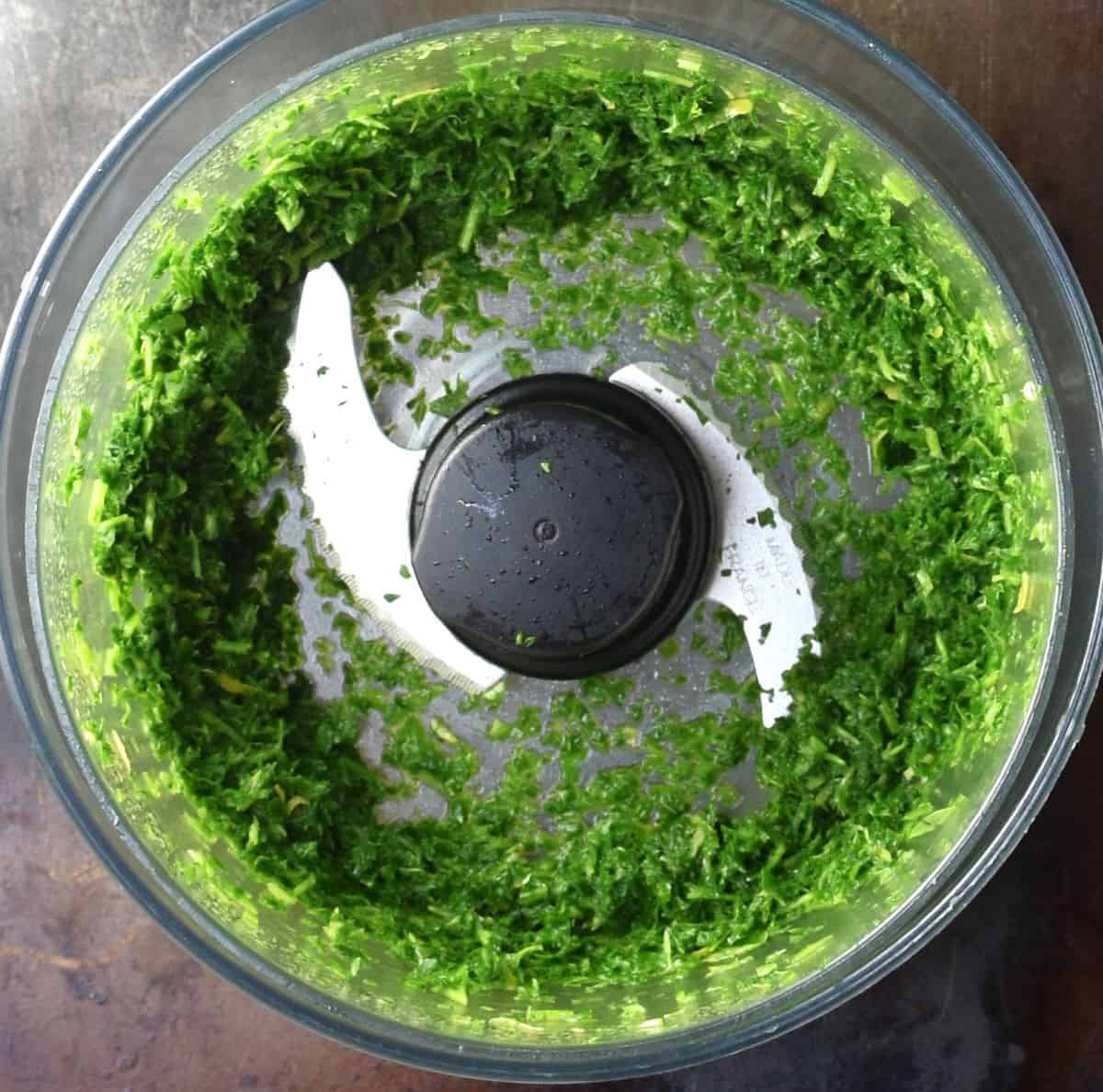 Finely chopped herb mixture in food processor bowl.