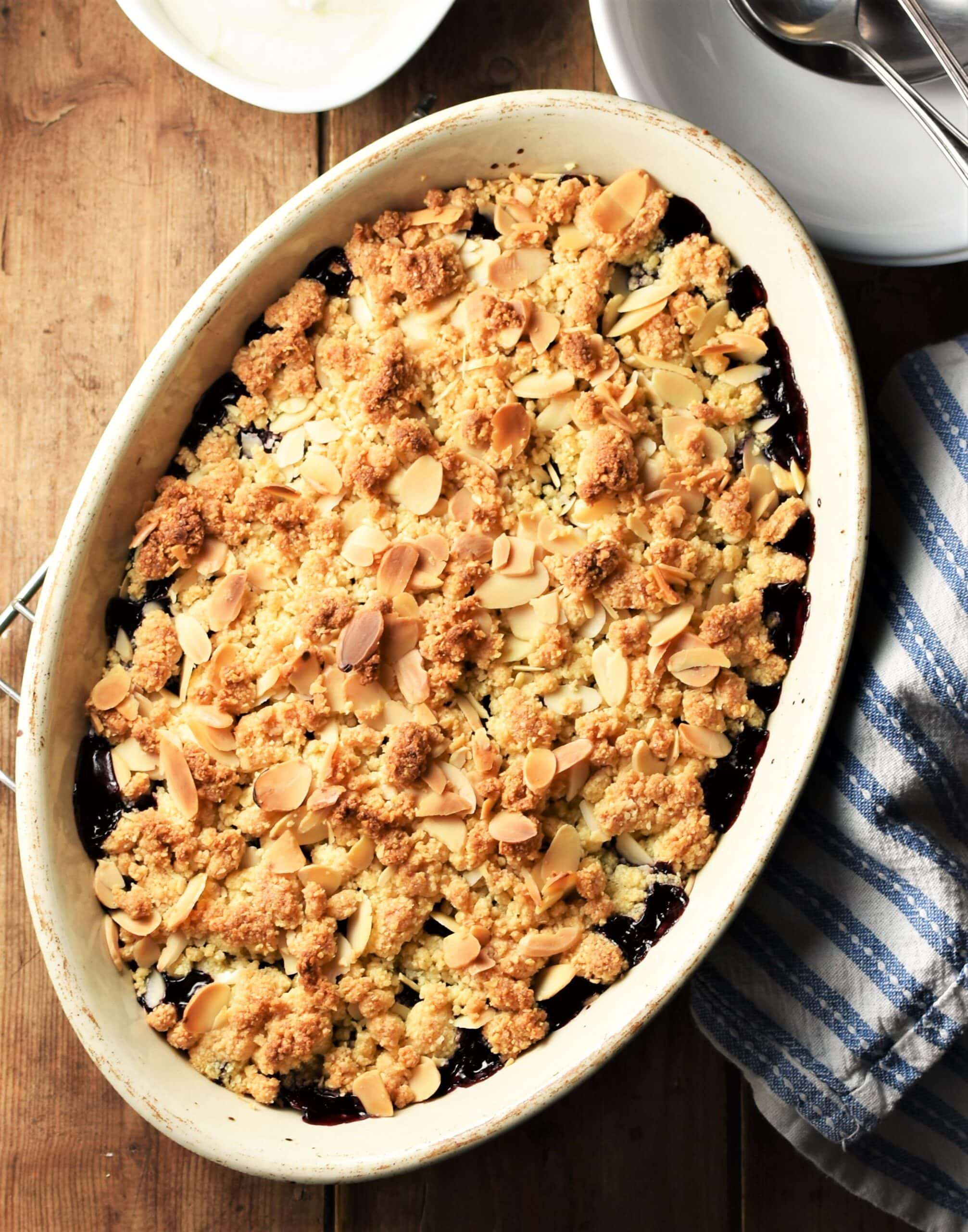 Top down view of cherry crumble in white oval dish.