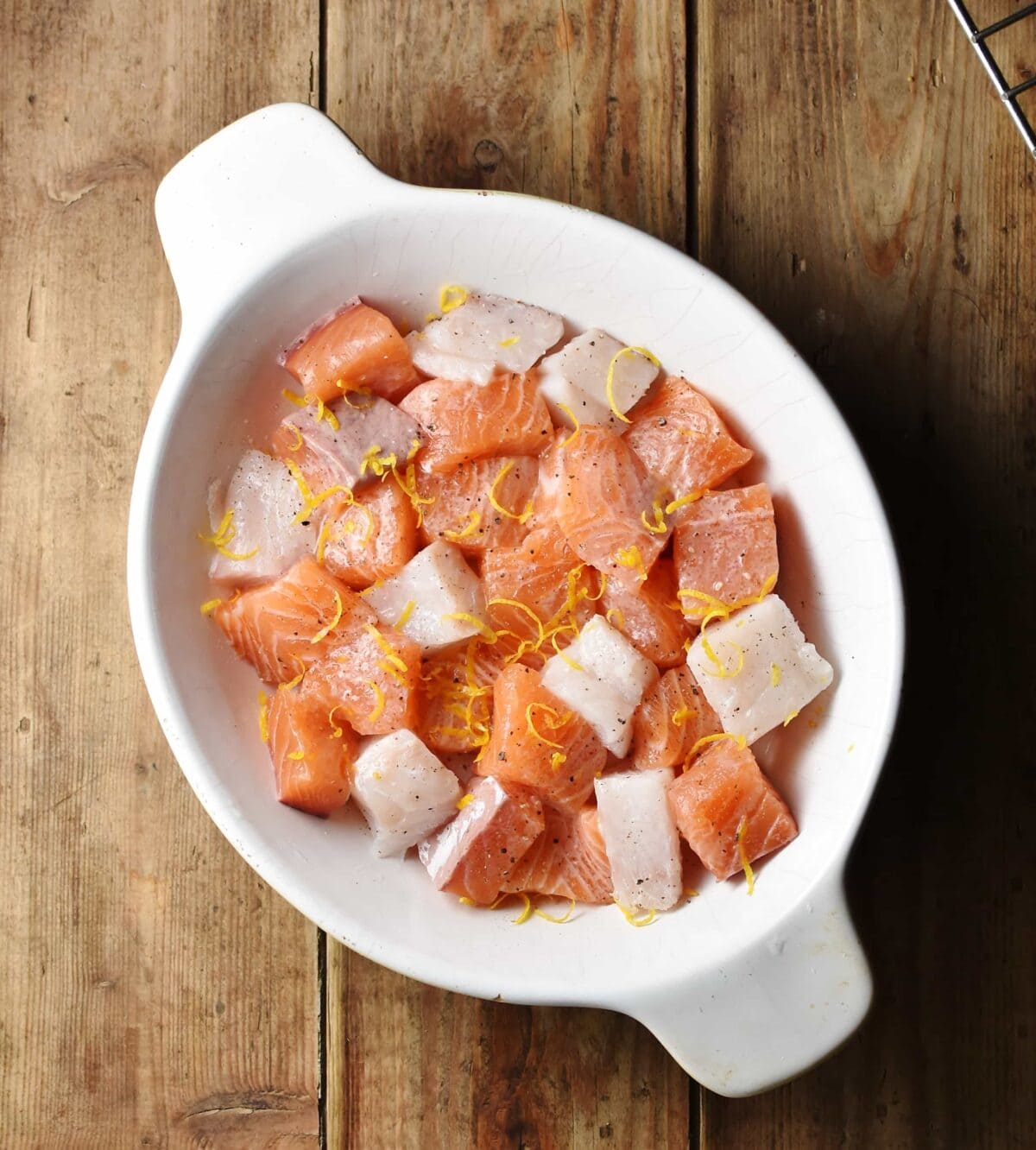 Raw fish pieces in oval, white dish.