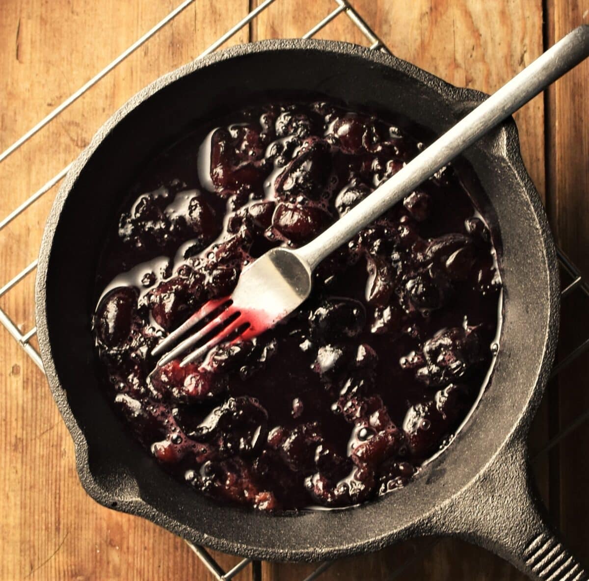 Cooked cherries in cast iron pan.