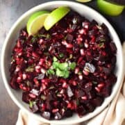 Top down view of beet salsa with live wedges in white bowl.