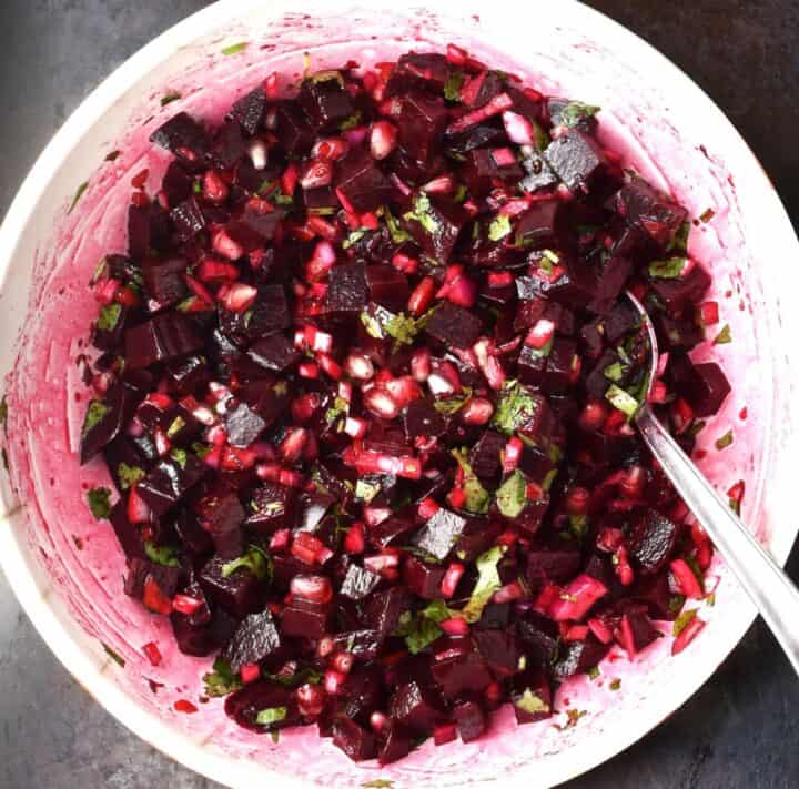 Assembled beetroot salsa in large mixing bowl with spoon.
