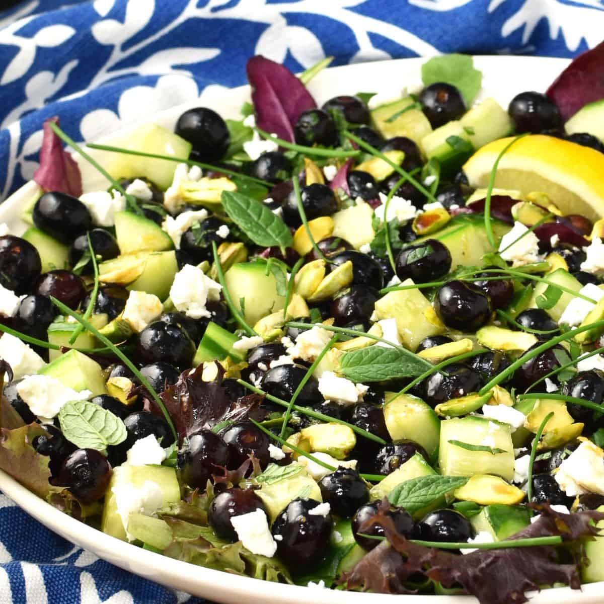 Close-up side view of blueberry salad on large plate.