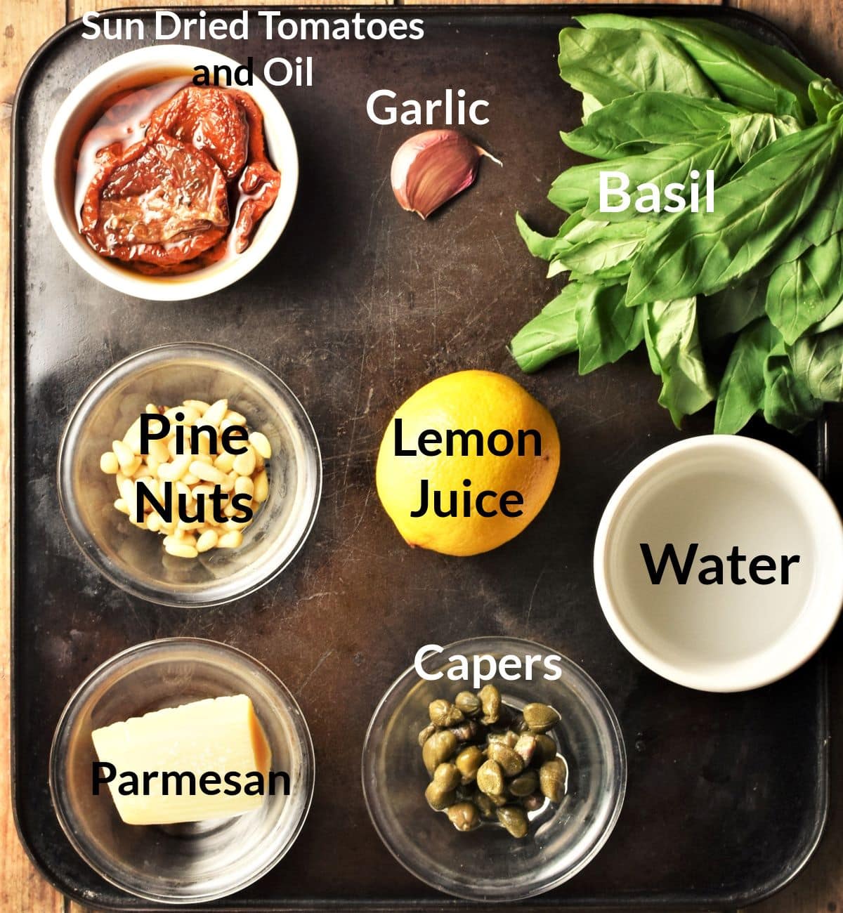 Ingredients for making sun dried tomato pesto in individual dishes.