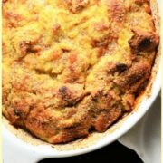 Top down view of banana french toast bake in white oval dish with white cloth to right.