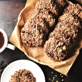Top down view of chocolate oatmeal cookies on top of parchment and small plate.