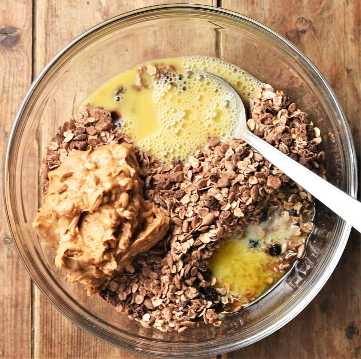 Breakfast cookies ingredients in mixing bowl with spoon.