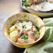 Salmon and potato bake in white-and-yellow bowl with green cloth.
