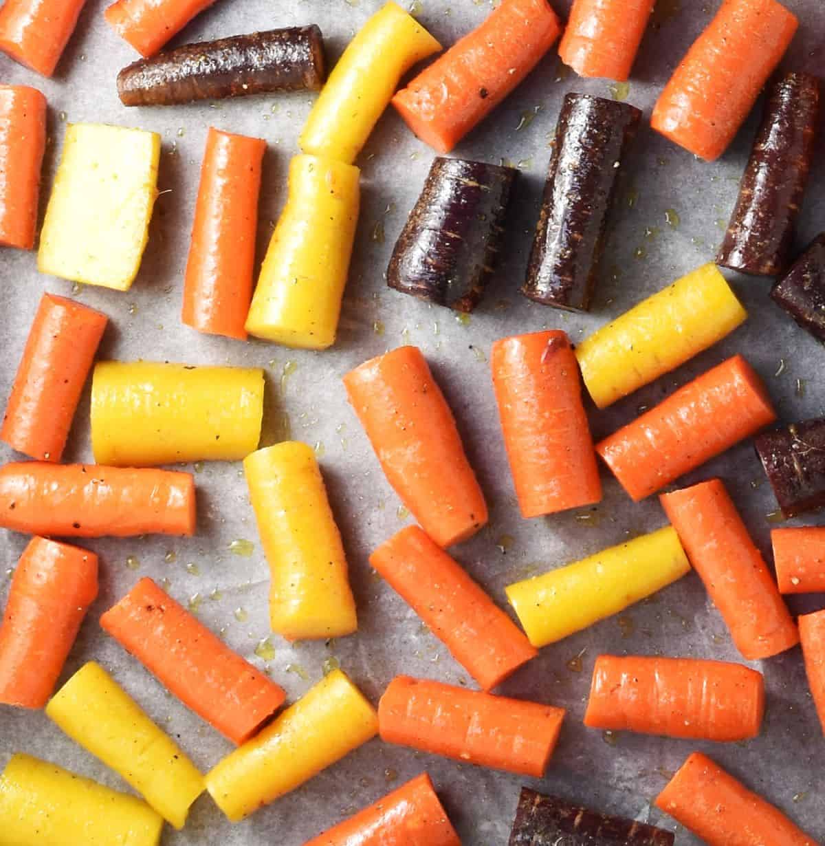 Different coloured carrot pieces on top of parchment.