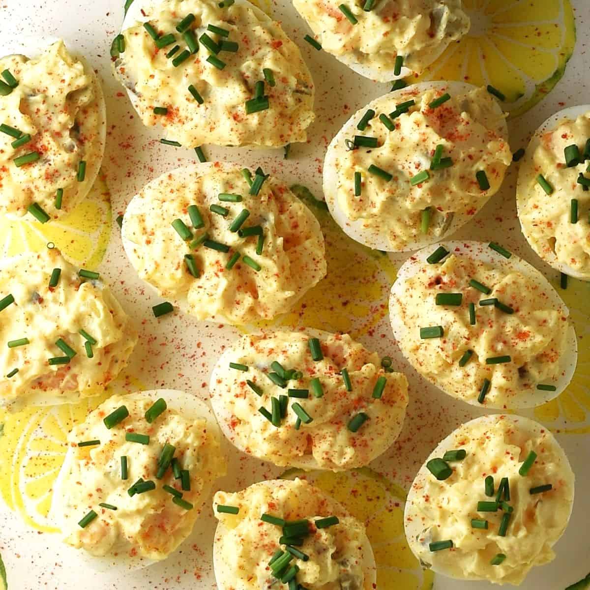 Top down view of deviled eggs stuffed with potato salad mixture and garnish of chives.