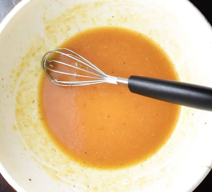 Miso glaze mixture in white bowl with whisk.