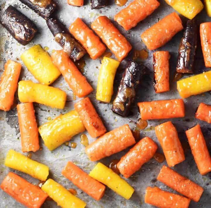Roasted carrot pieces covered with miso glaze on parchment.