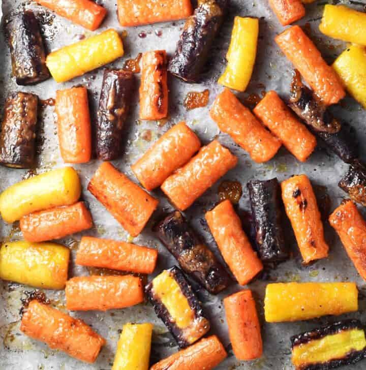 Miso roasted caramelised carrot pieces on top of parchment paper.