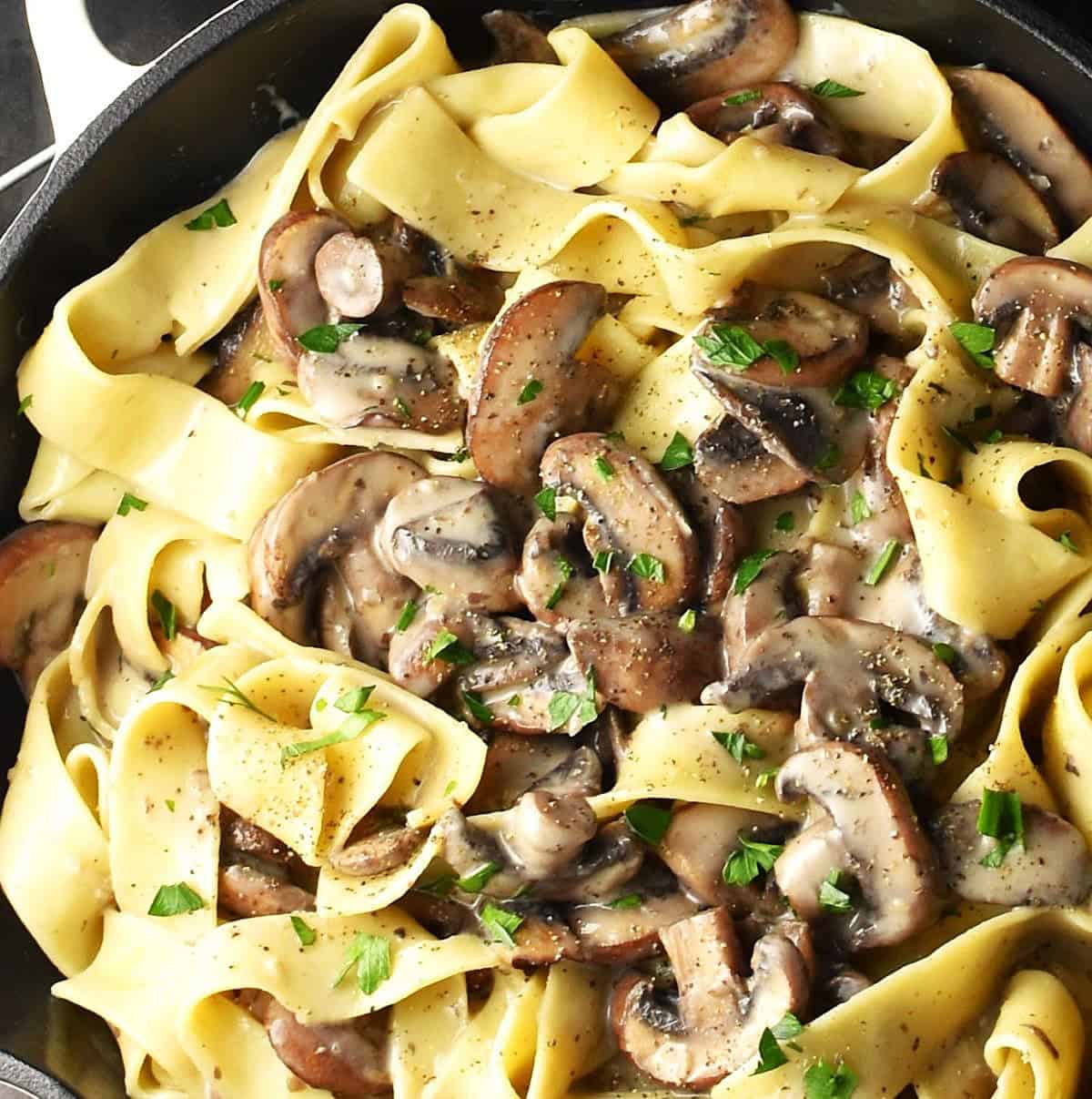 Close-up view of no cream mushroom pasta in skillet.