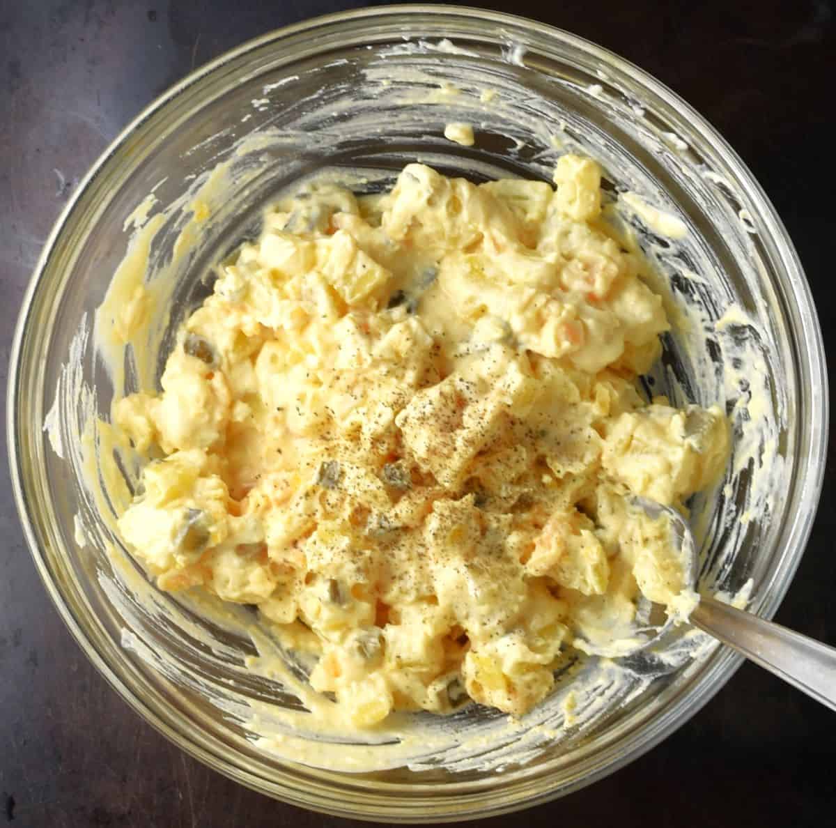 Creamy potato salad for deviled eggs in bowl with spoon.