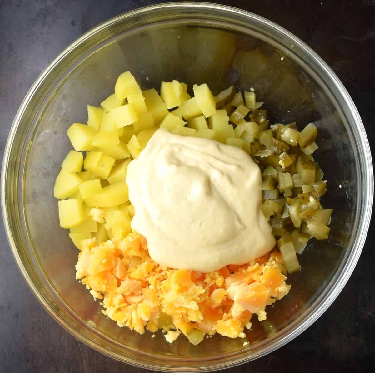 Ingredients for making potato salad deviled egg mixture in bowl.